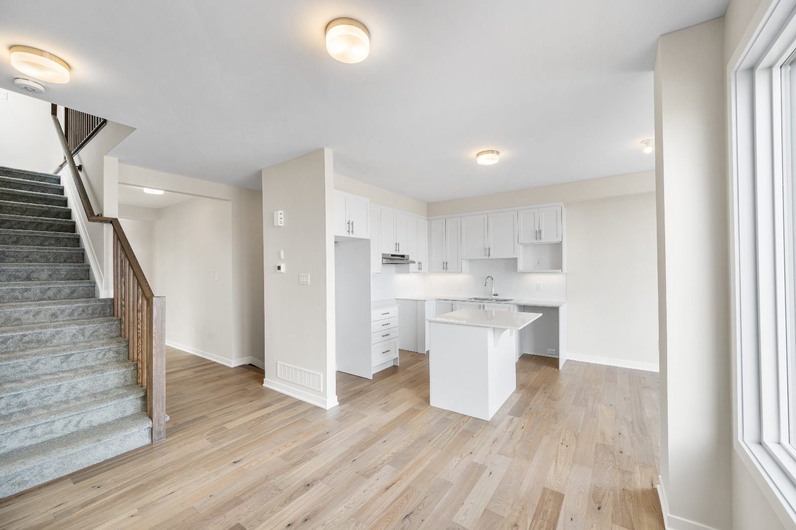 Staged living room and kitchen with natural light