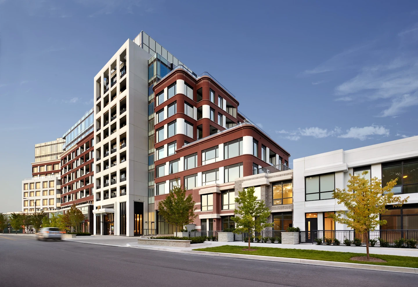 Edenbridge Kingsway exterior: a completed mid-rise of red brick and white stone with glass upper levels and street-front townhomes