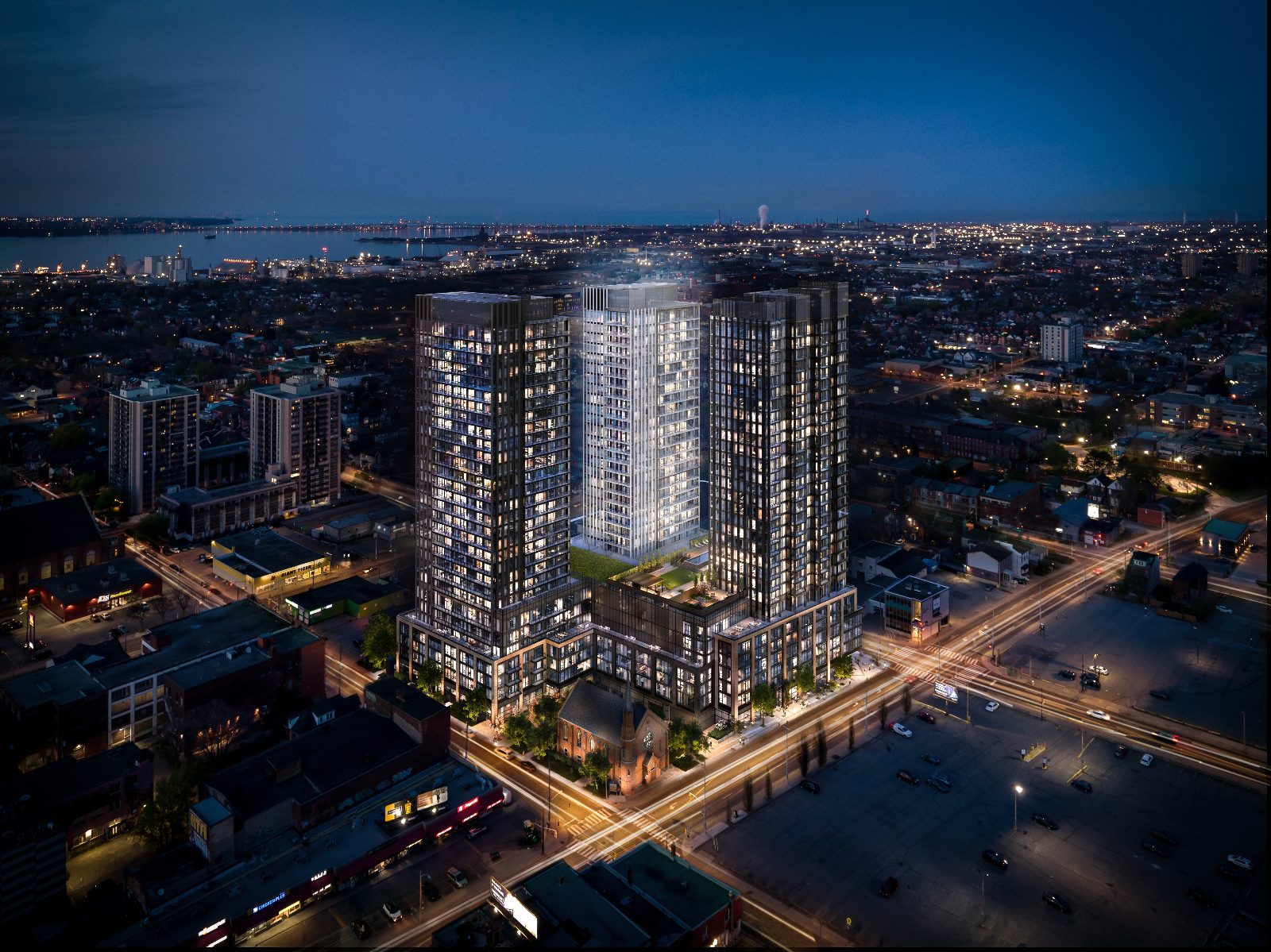 Night aerial view of The Design District towers lit up over downtown Hamilton